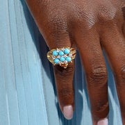 Lupita's hand with the frog ring and her other hand with a jeweled ring