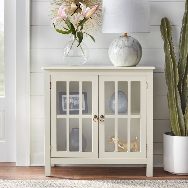 An ivory cabinet with transparent door panels