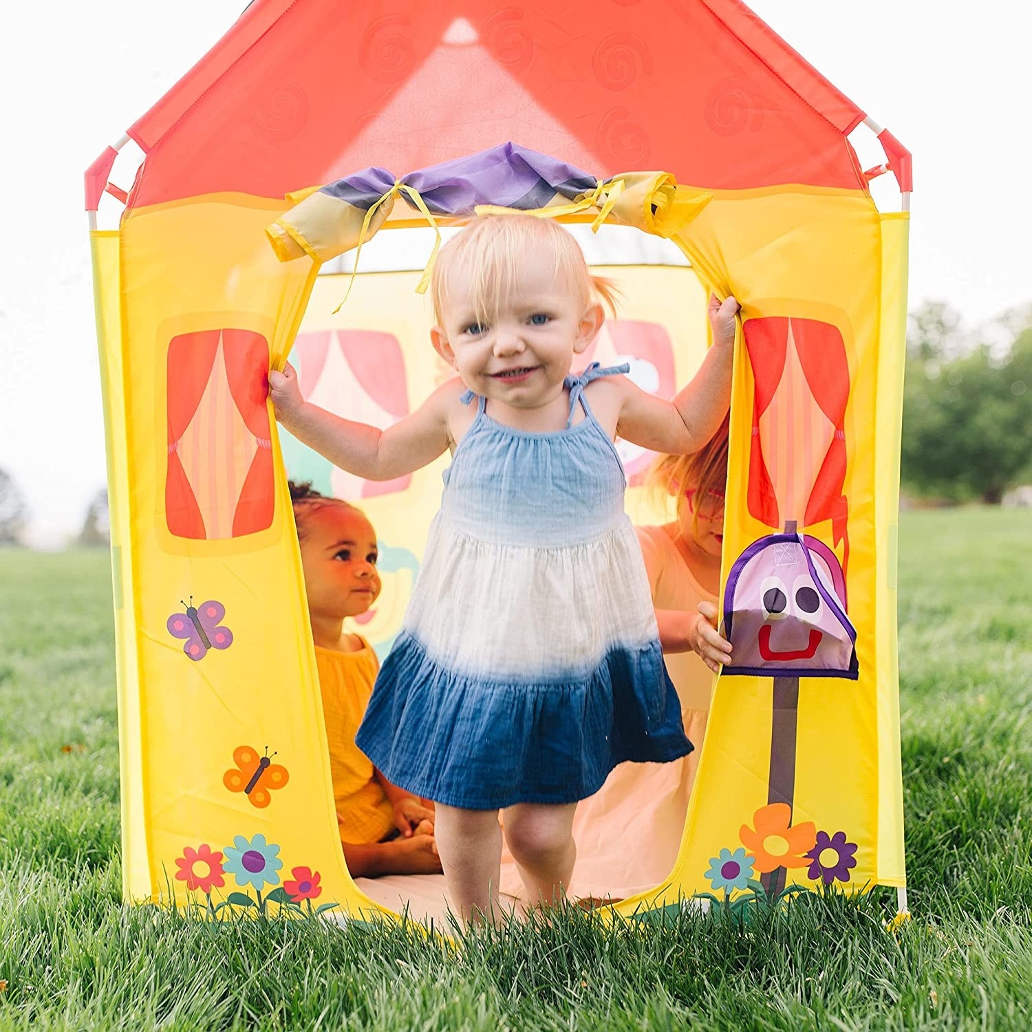 A small child in front of a colourful tent