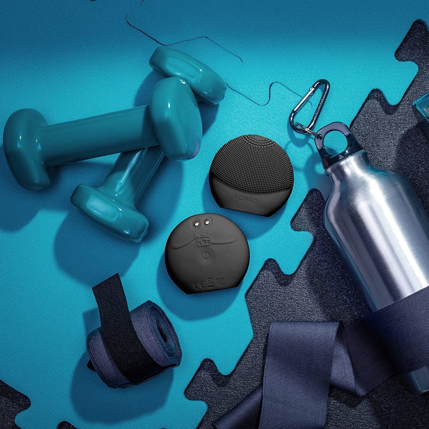 Two Foreo devices surround by gym equipment