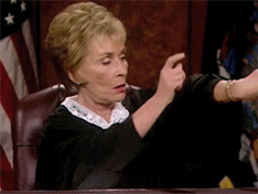 Judge Judy pointing at her watching and slapping her podium