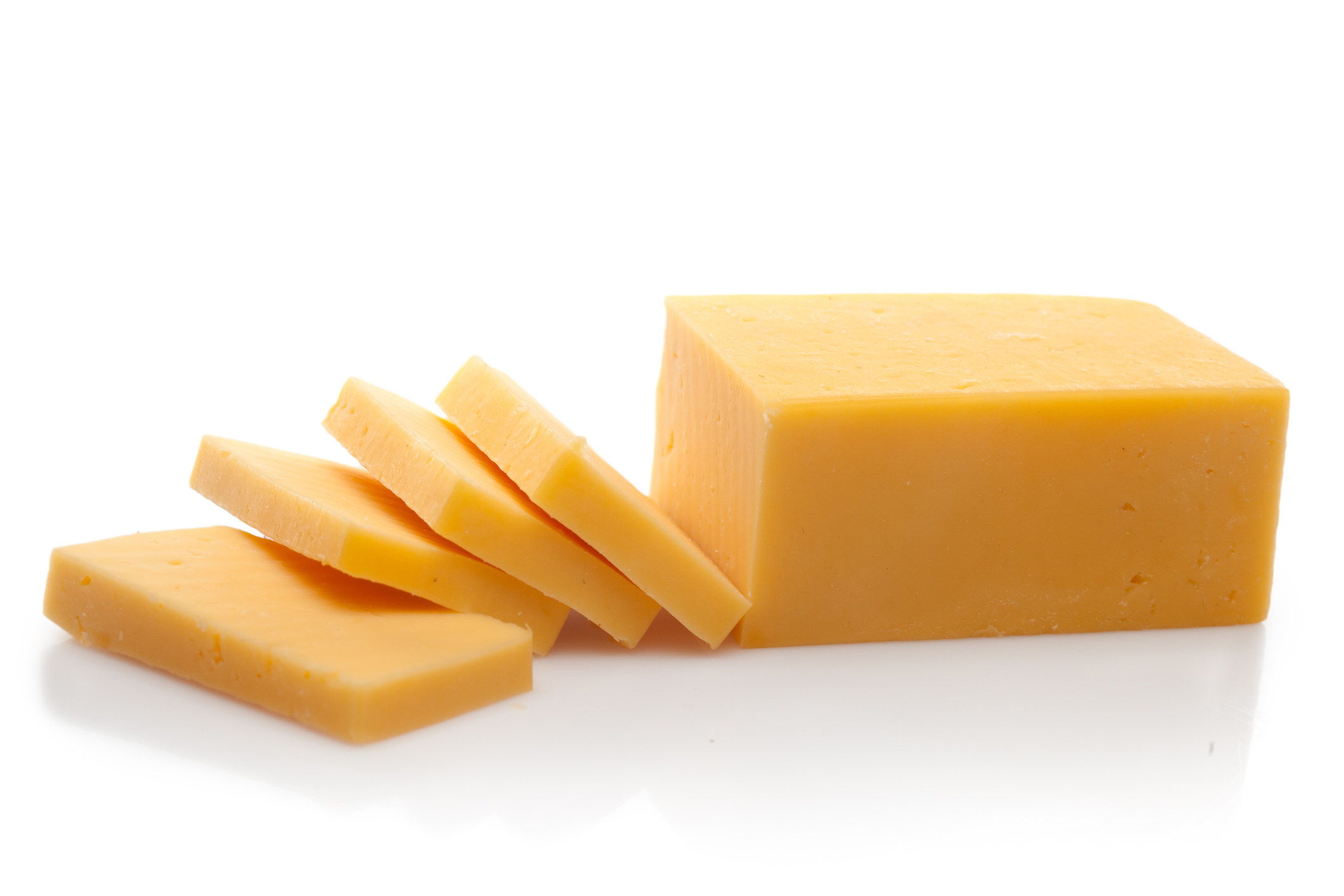 A block of Cheddar with slices