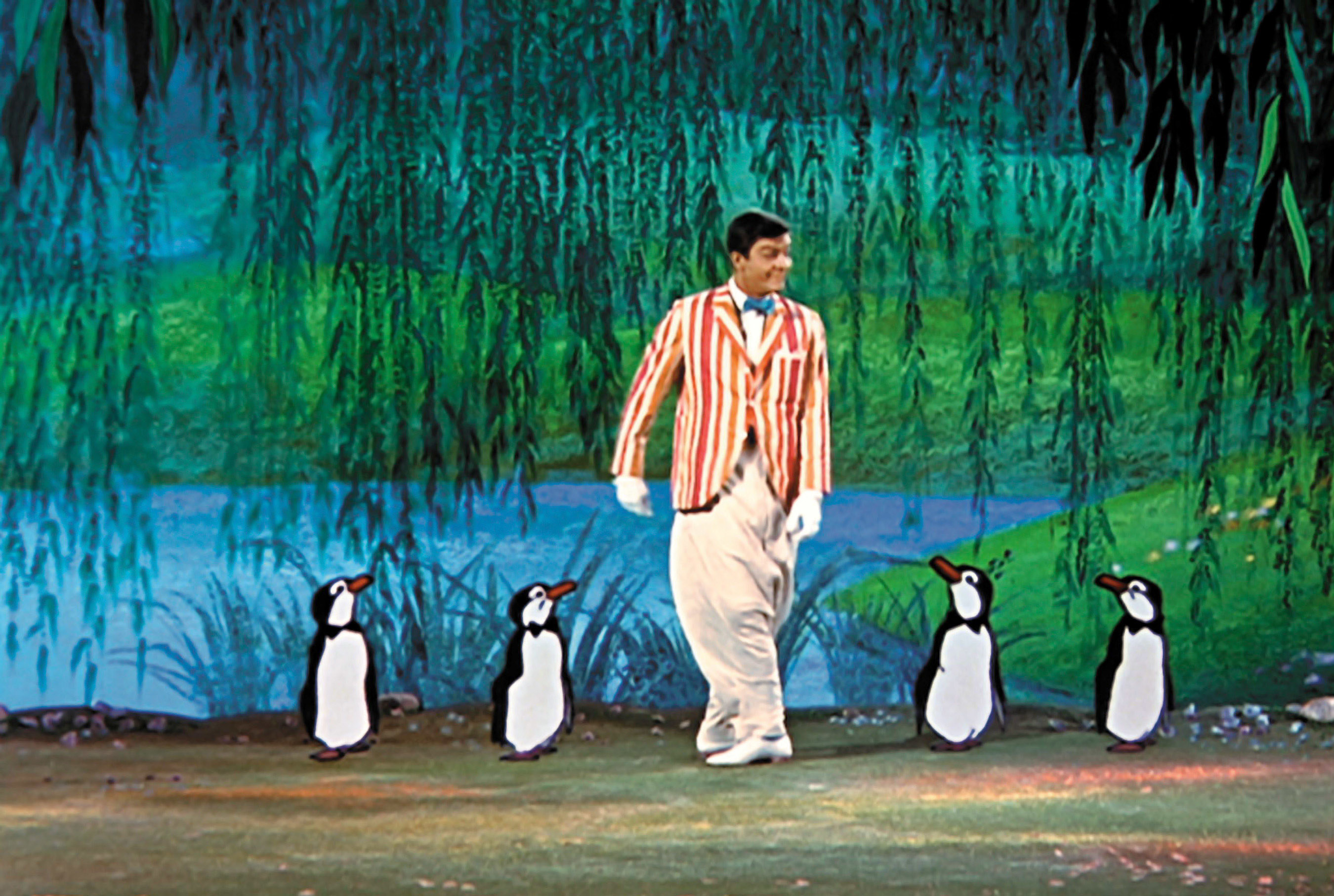 Dick Van Dyke with a bunch of cartoon penguins