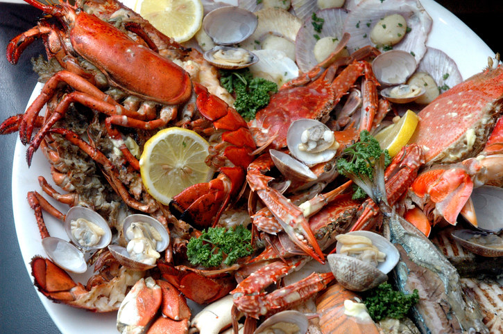 A plate packed with lobsters, crabs, and other seafood