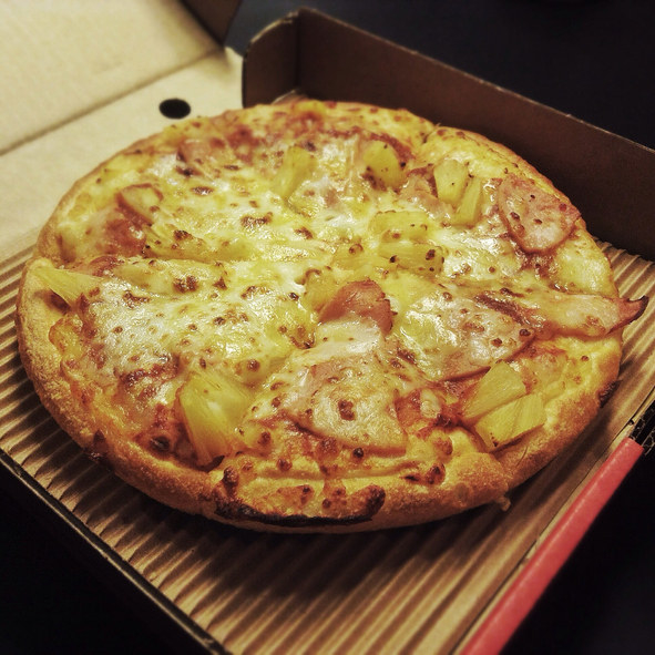 A pizza pie smothered with pineapple