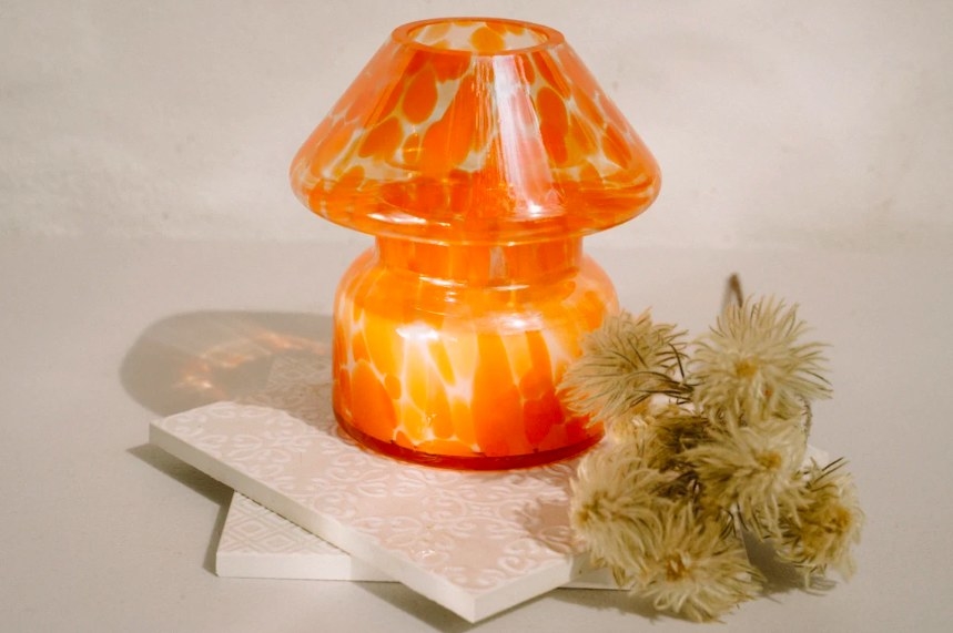 glass candle with mushroom top and orange splotchy design