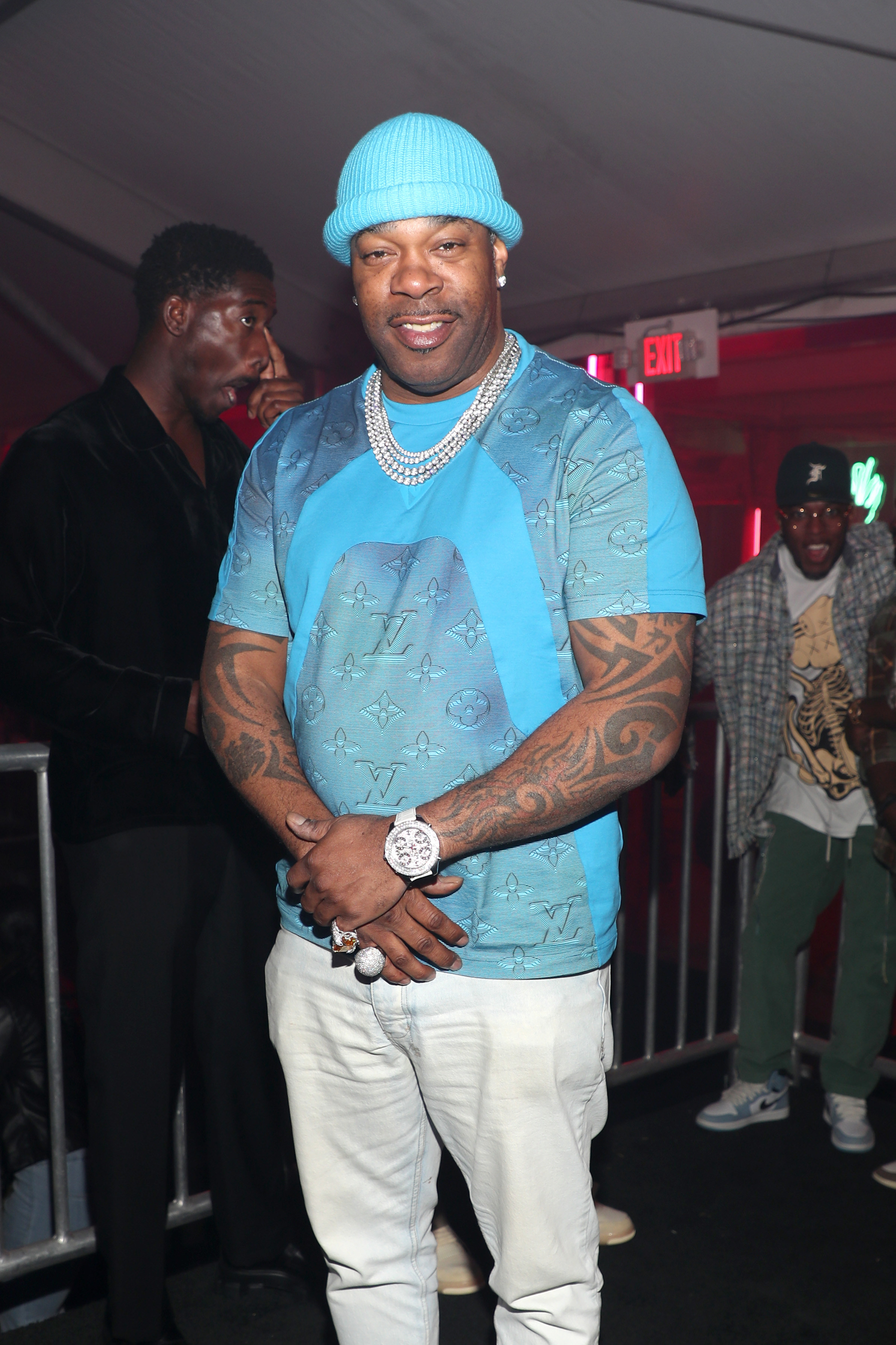 Busta Rhymes standing and smiling at a venue