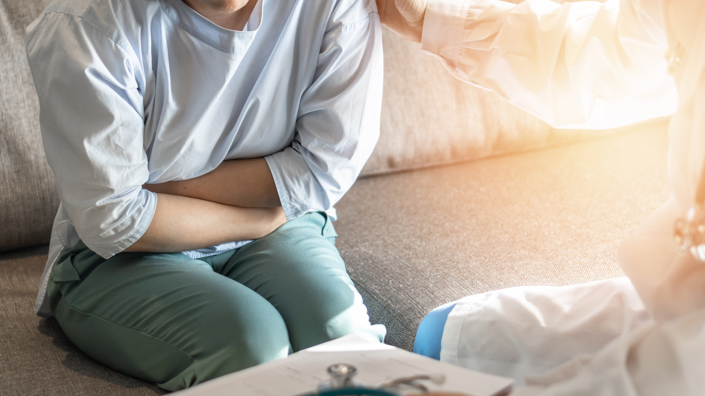 A woman holds her abdomen in pain