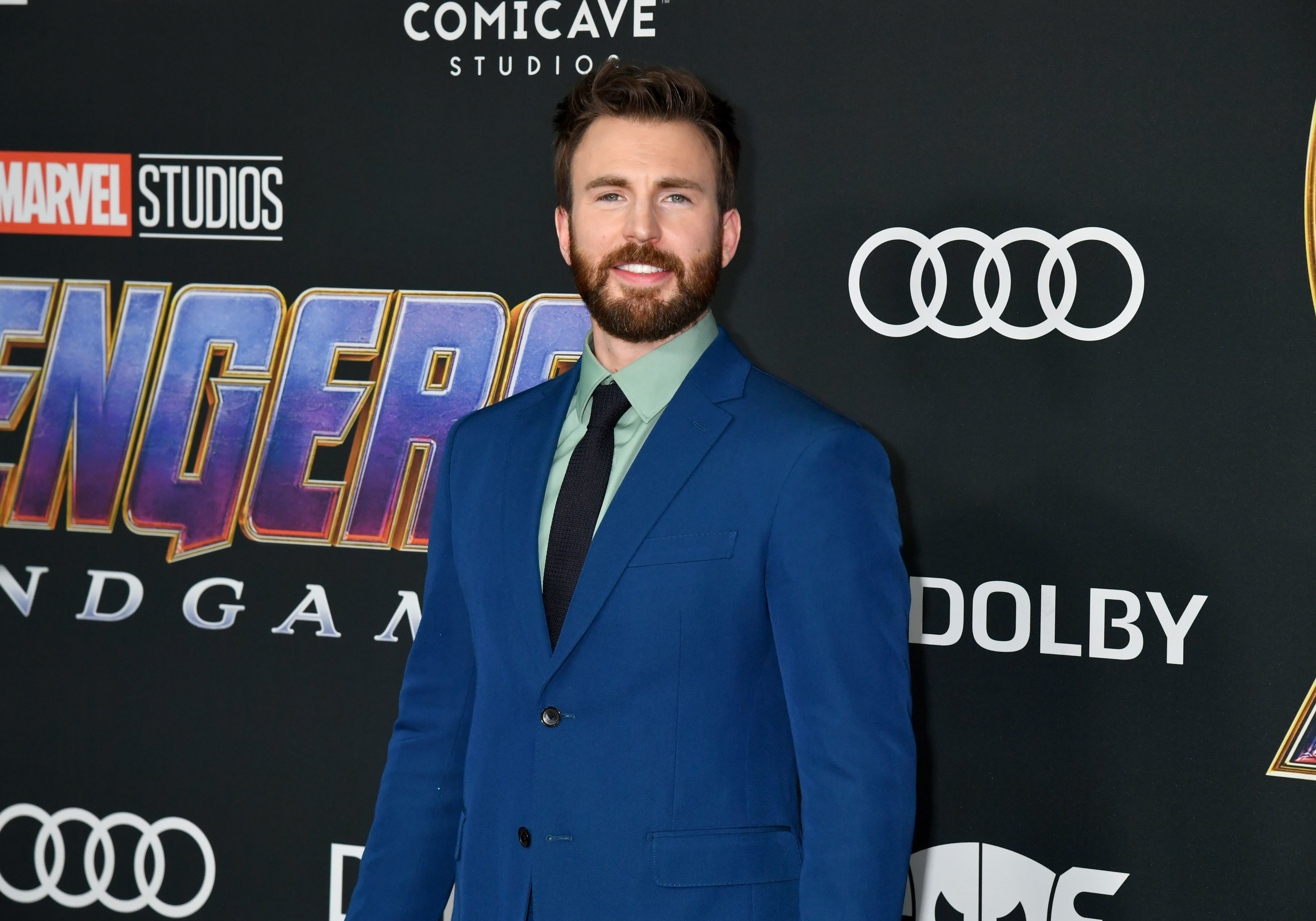Chris smiling, wearing a blue suit, at the Avengers Endgame premiere