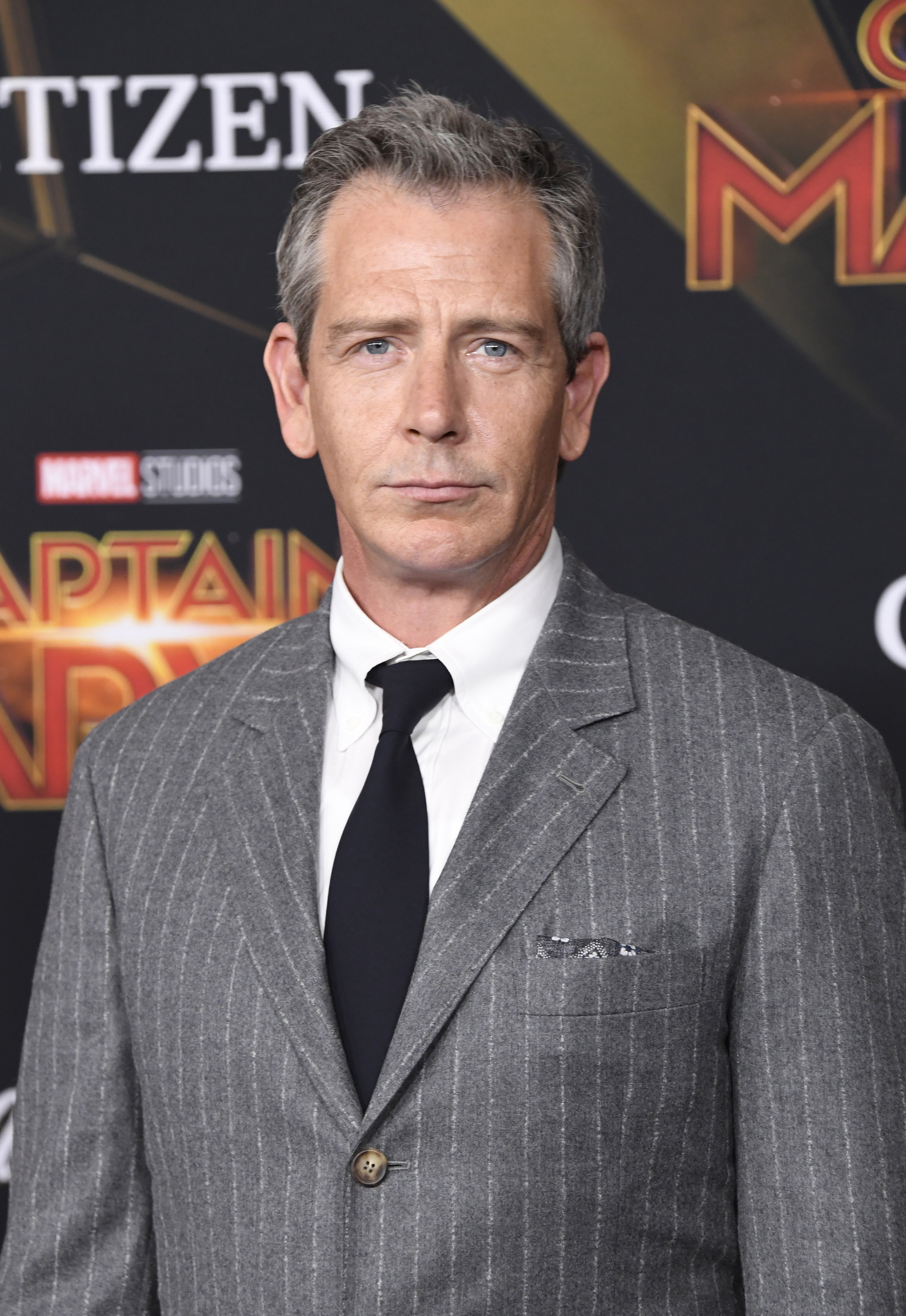 Ben at the Captain Marvel premiere in a grey pinstripe suit with a black tie and white shirt