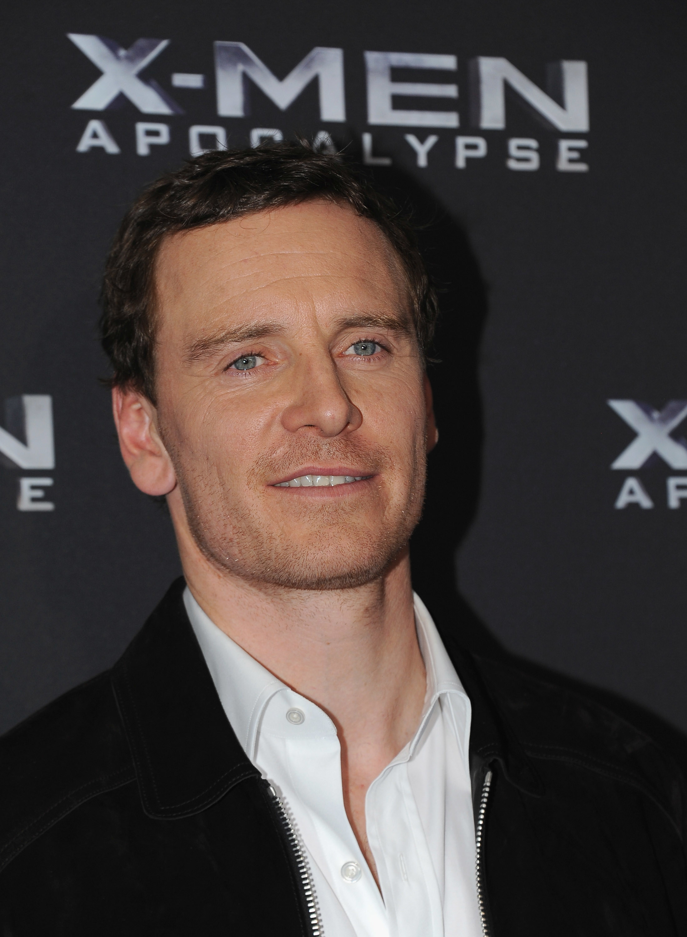 Head and shoulders shot of Michael smiling in a white shirt with a black zipped jacket at the X-Men Apocalypse premiere