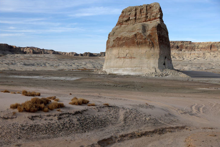 A photo of the same rock formation taken from the same spot, where there now is no water in sight