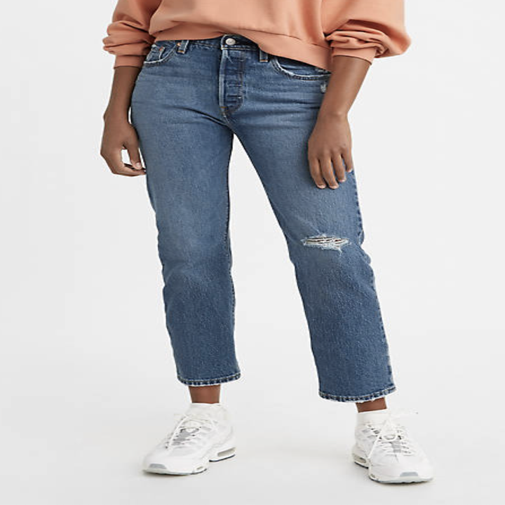 A person wearing jeans and sneakers