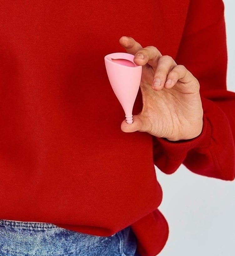 someone holding up the angled menstrual cup