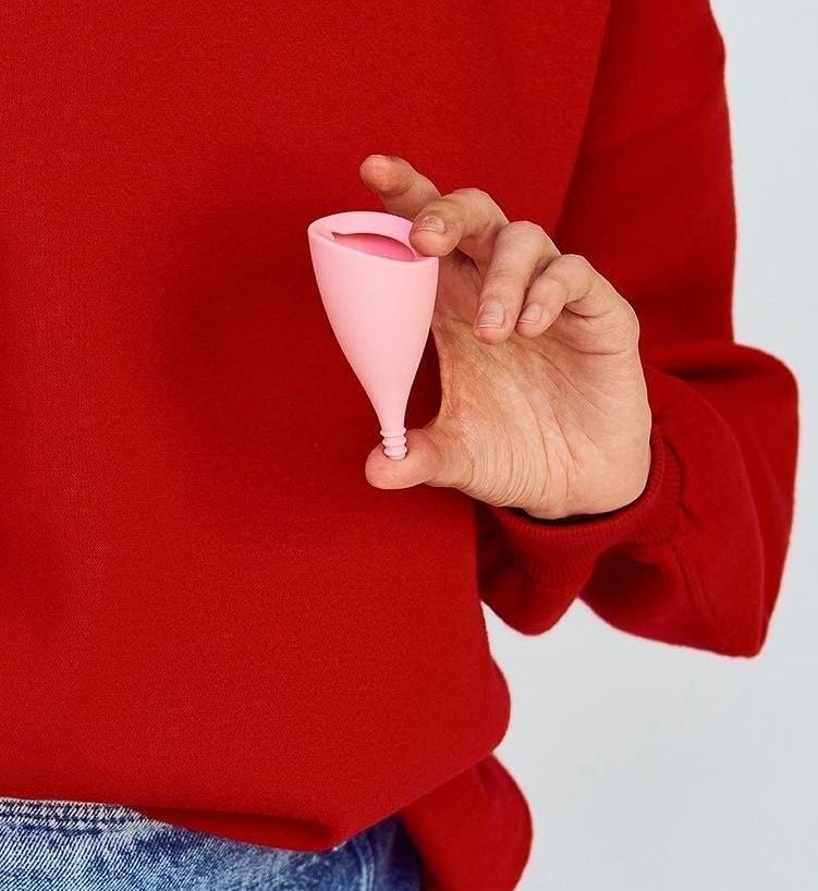someone holding up the angled menstrual cup
