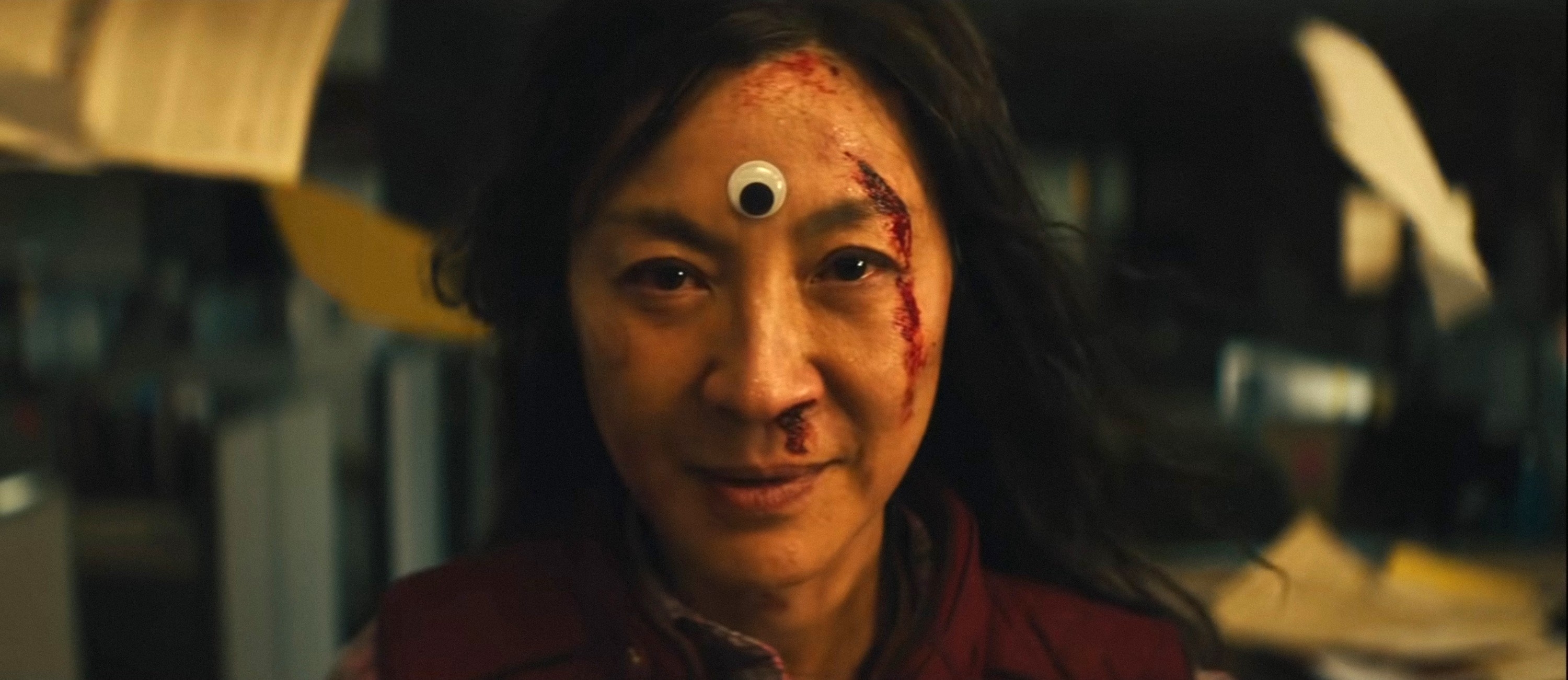 Michelle Yeoh in Everything, Everywhere, All At Once with a googly eye on her head