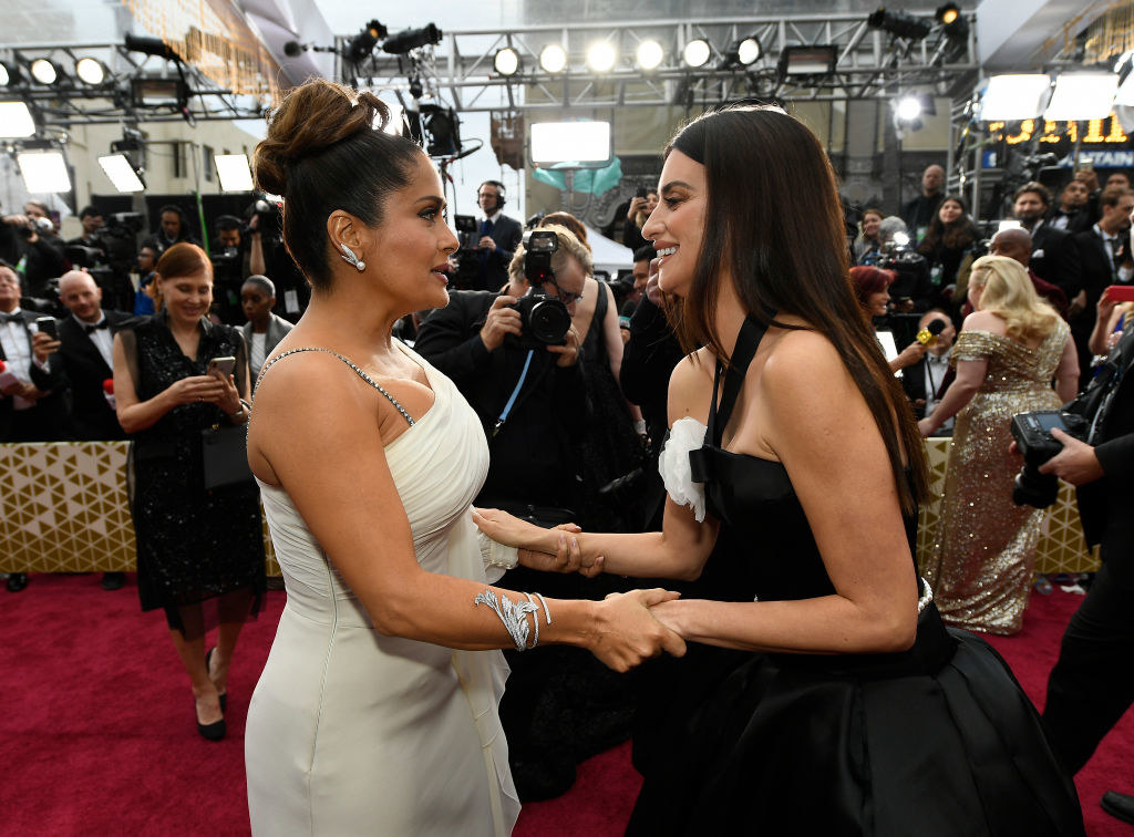Salma and Penélope clasping each other&#x27;s hands on the red carpet