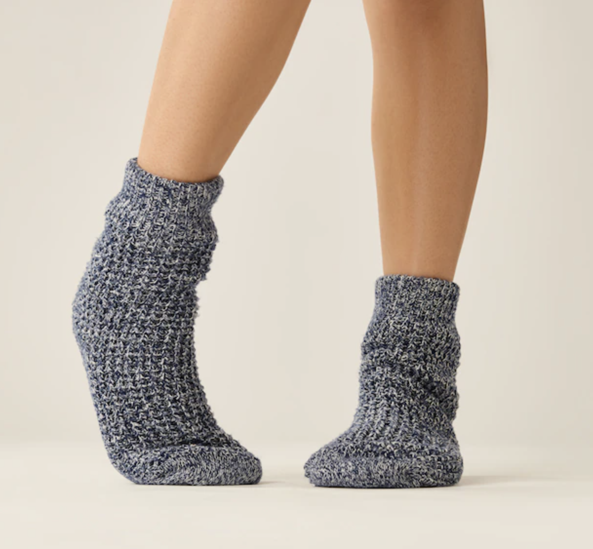 a close up of a person wearing the waffle-knit sherpa lined socks on their feet