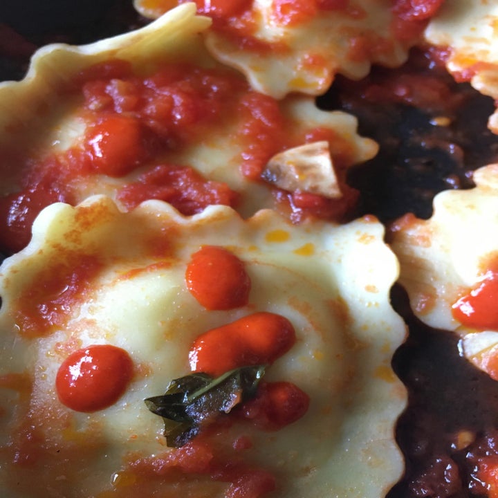 Some Truff hot sauce drizzled over ravioli with tomato sauce, garlic, and roasted garlic