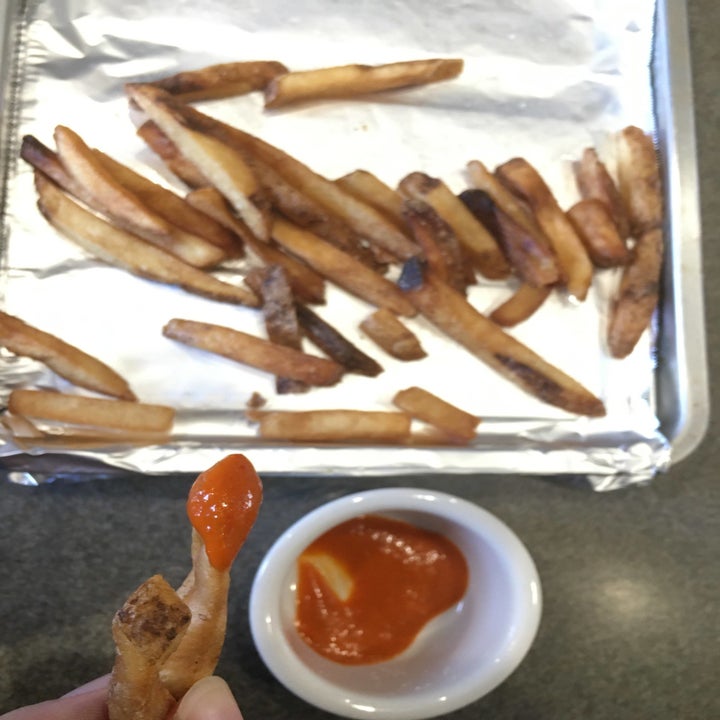 The writer dipping fries into some Truff hot sauce