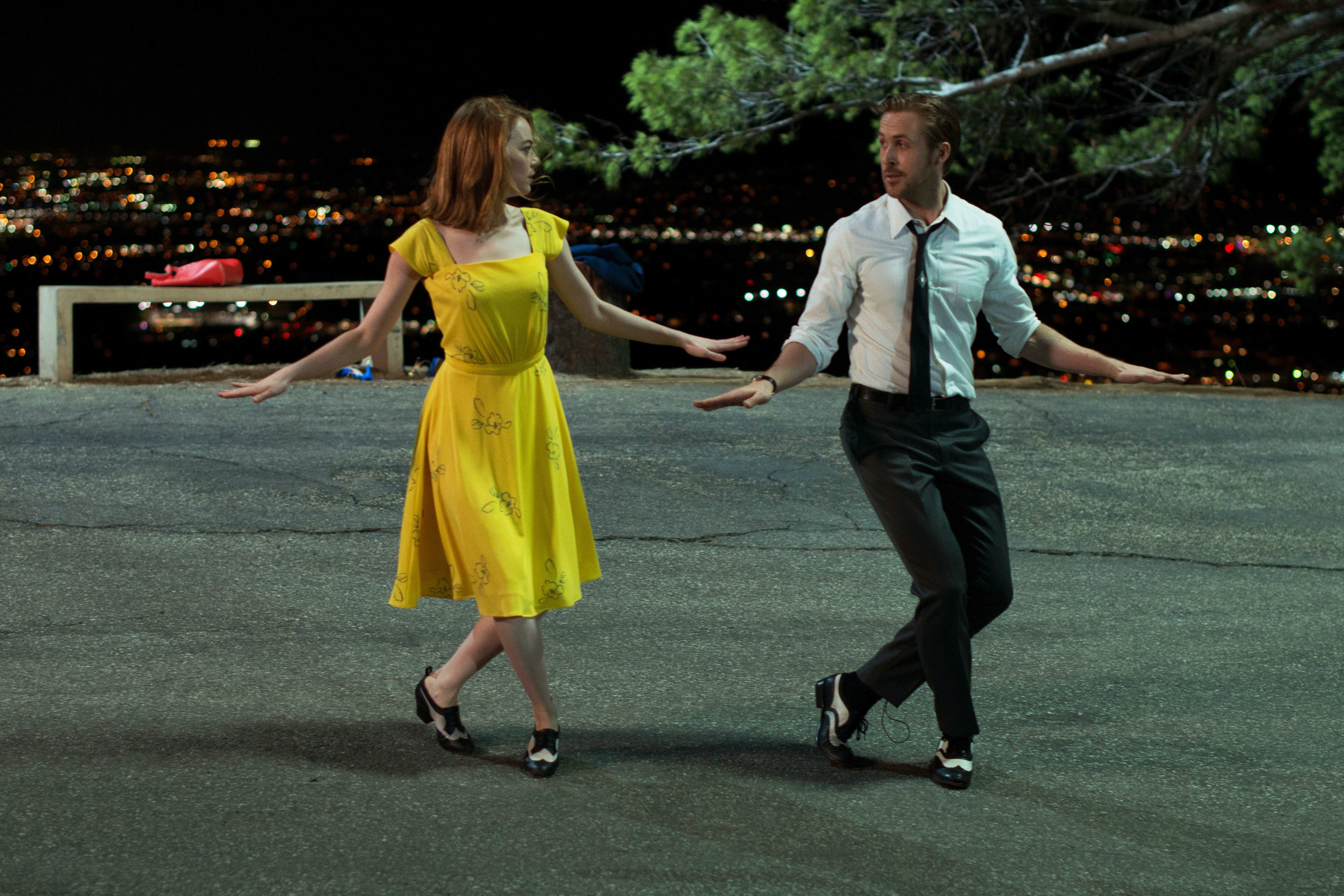 Emma Stone and Ryan Gosling dancing in the street at night