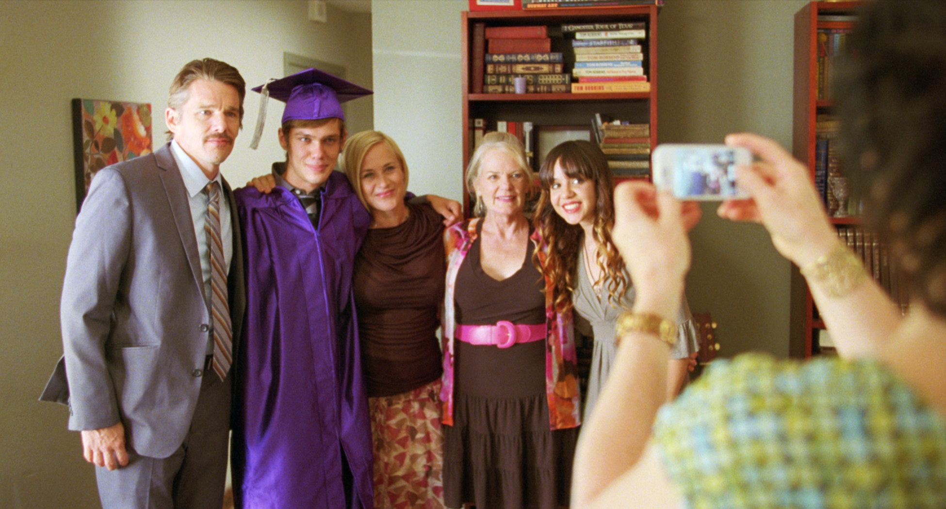 a character taking a photo of the family after graduation in the movie