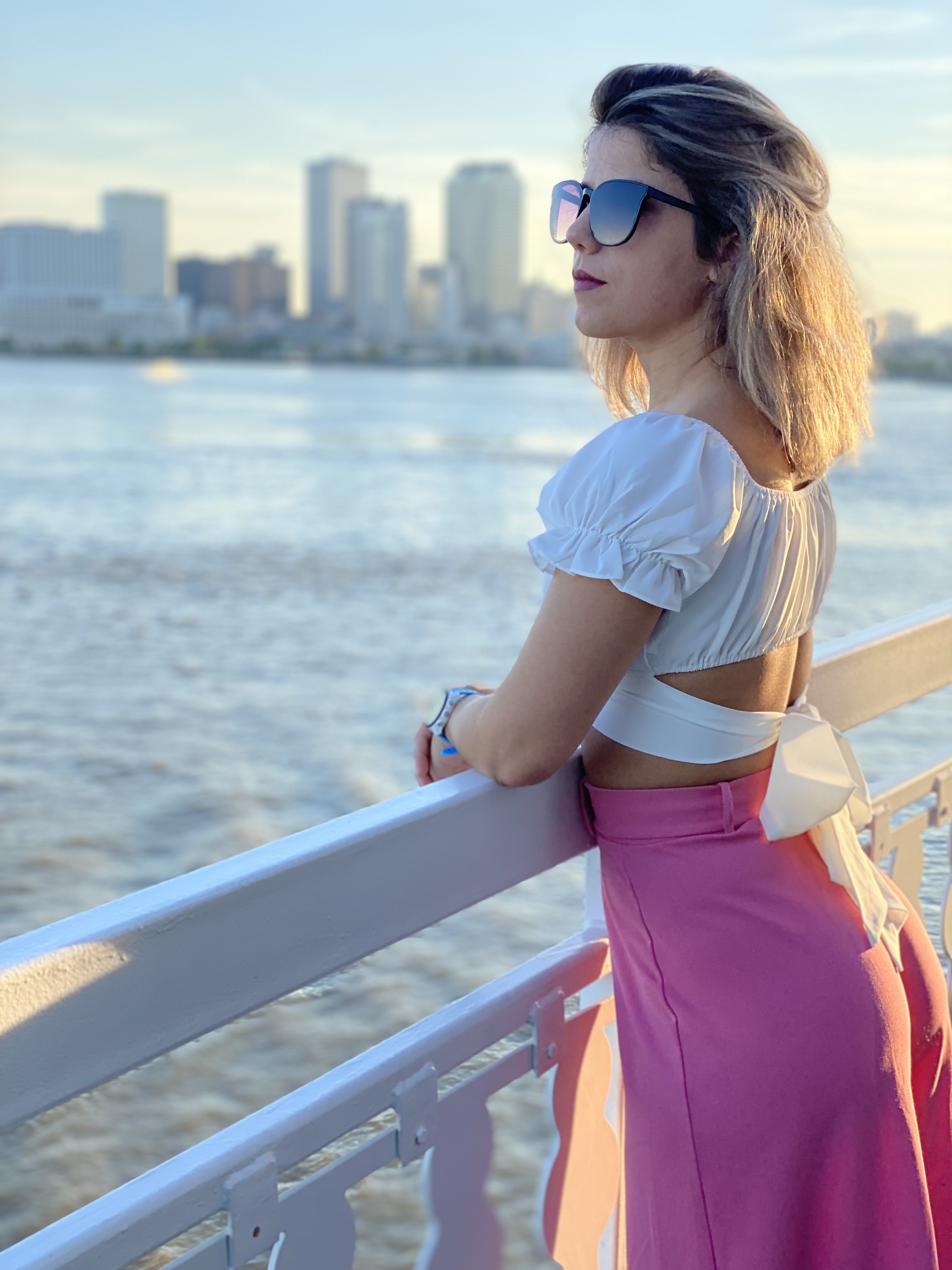 a reviewer showing the bow on the back of the white top with a pink skirt