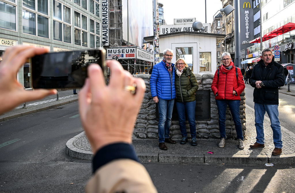 tourists taking a photo by the small memorial with a McDonalds in the background
