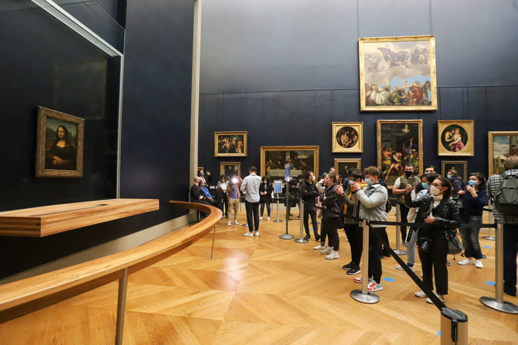 visitors taking photos of the Mona Lisa behind the sectioned-off rope