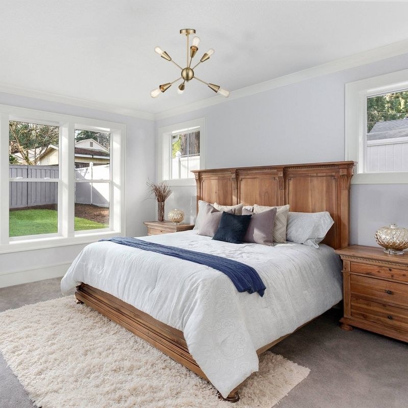 a staged bedroom with a mounted ceiling light