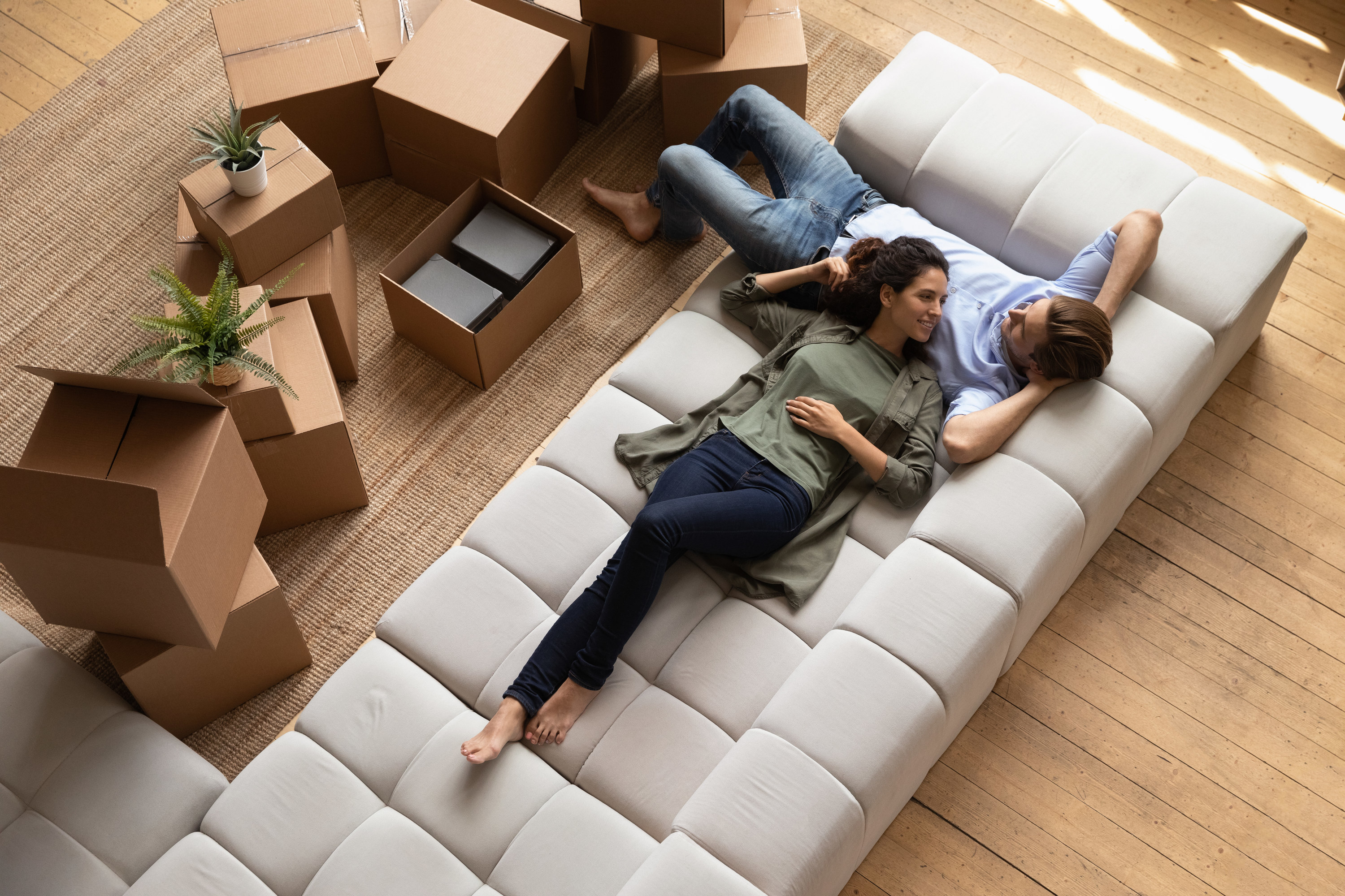 couple laying on the couch in the middle of moving