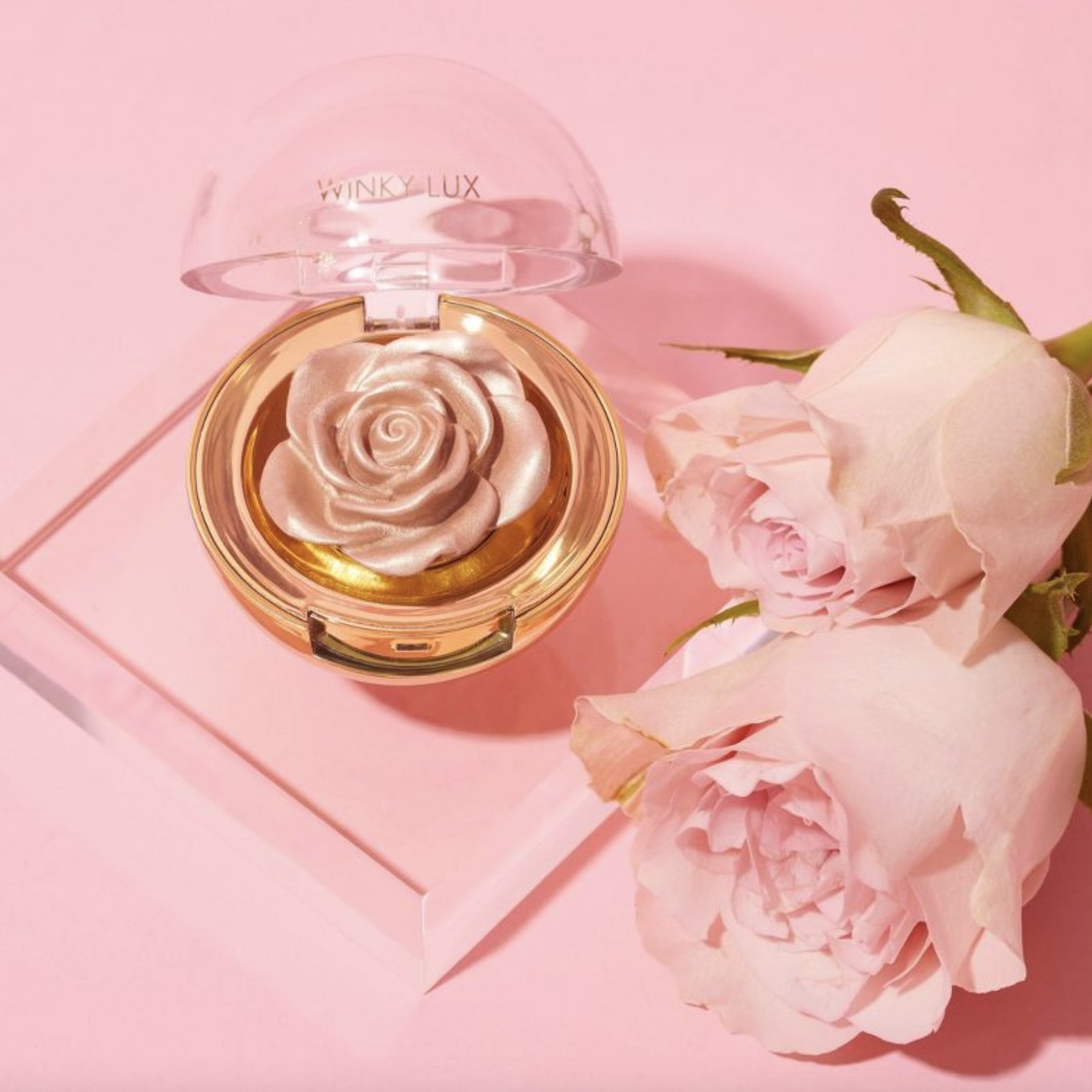 A rose shaped makeup highlighter with two pink roses
