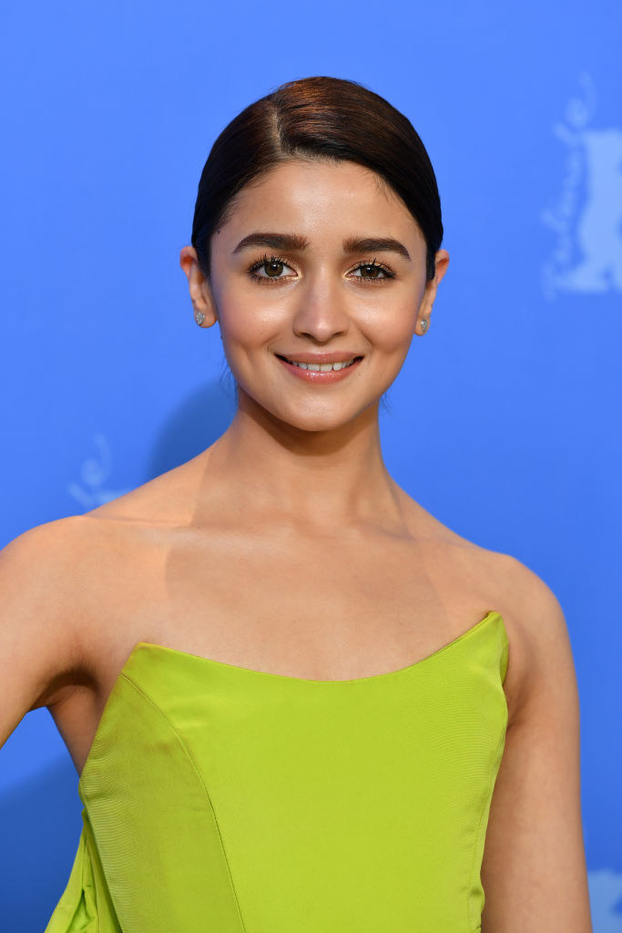 Alia Bhatt, wearing an off-shouldered lime green gown, poses for a photograph