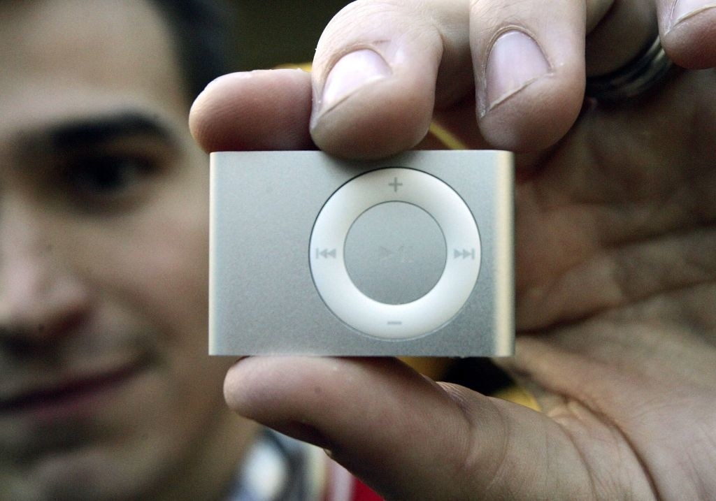 A tiny iPod with no screen held up between two fingers
