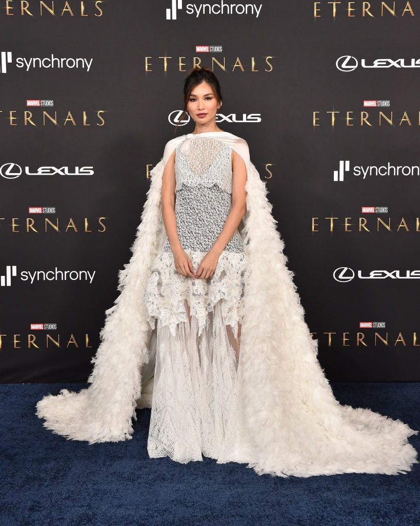 Gemma Chan wearing multilayered dress with a cape