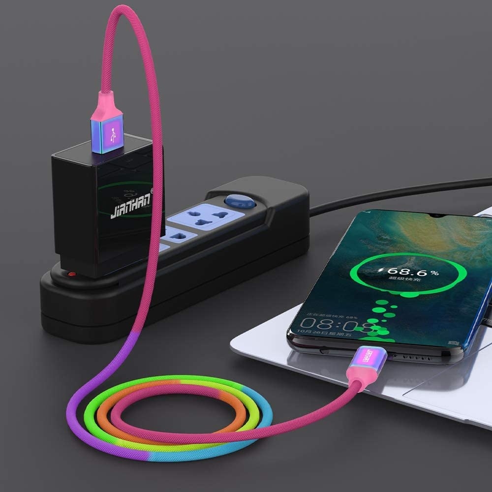 A phone with a rainbow charging cord in its socket