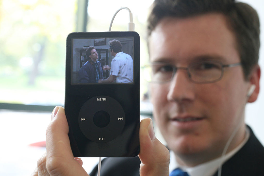 Man holding up an iPod showing a scene from Seinfeld