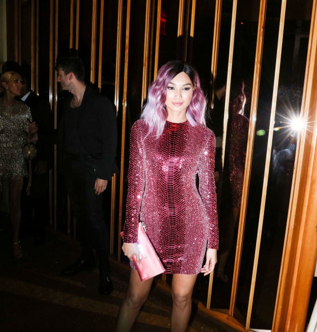 Gemma Chan in a short sequined dress and matching reddish purple hair