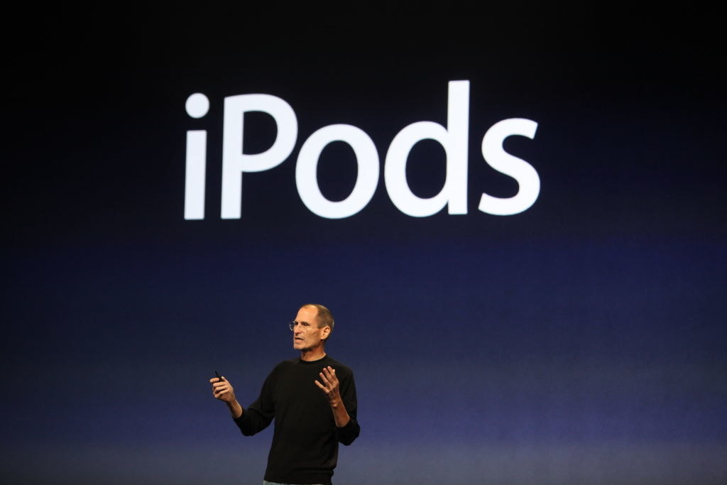 Steve Jobs onstage with the text &quot;iPods&quot; above him