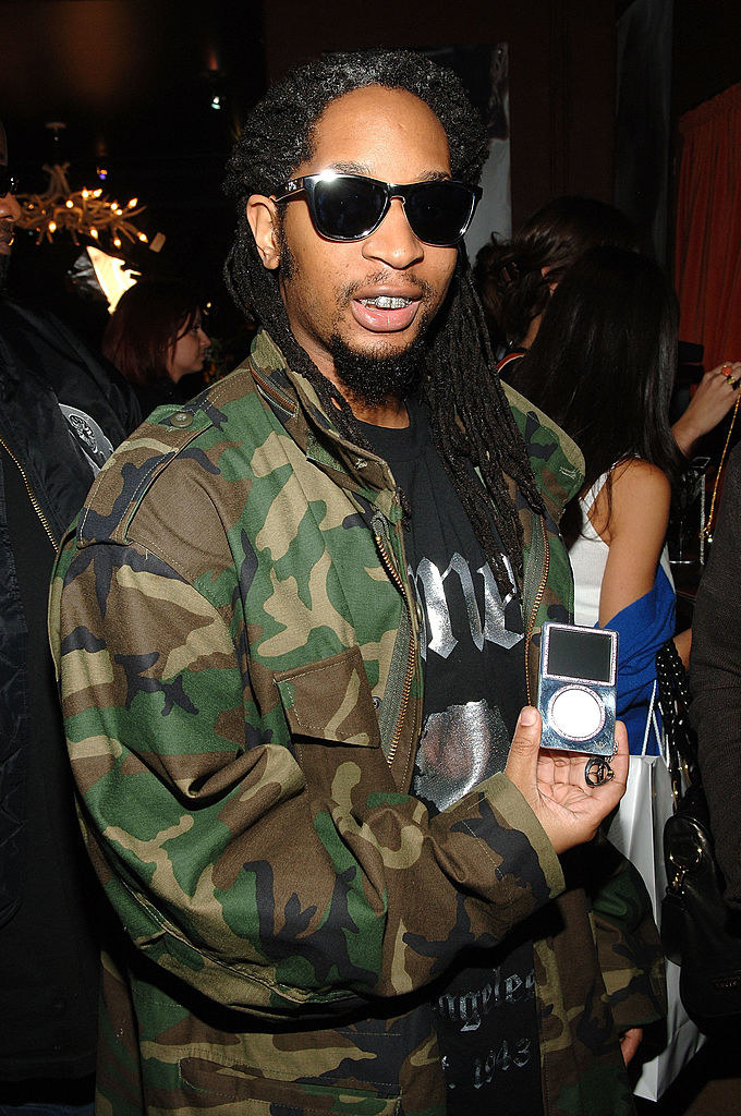 Lil Jon, wearing a camo jacket and sunglasses, holds up an iPod