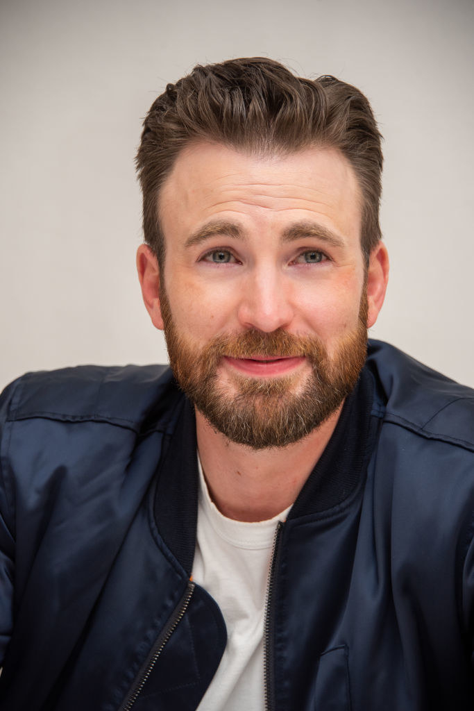 Chris smiling in front of a plain backdrop