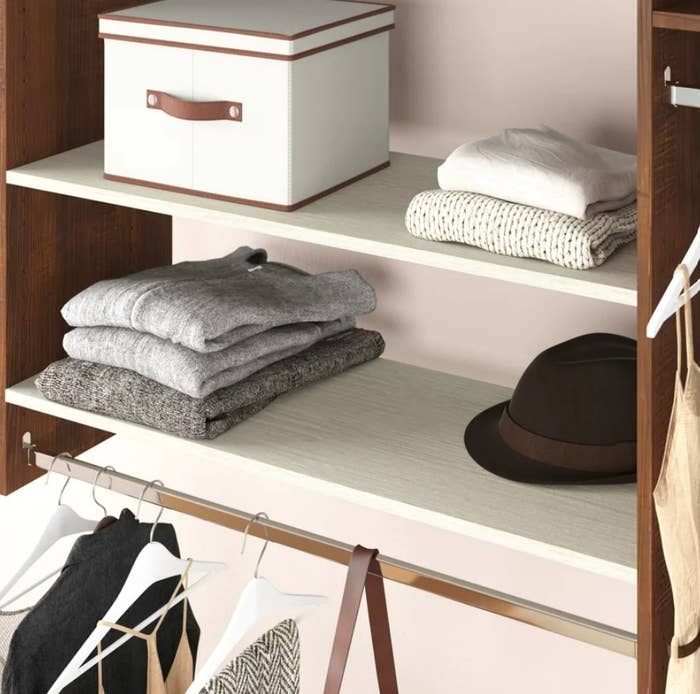 White shelves with folder shirts and hat to show use