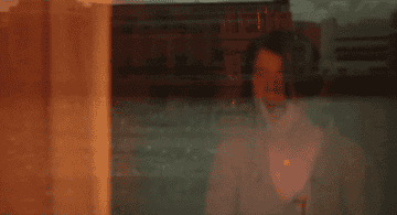 GIF of a woman in the film yelling as she looks out a window at the rain