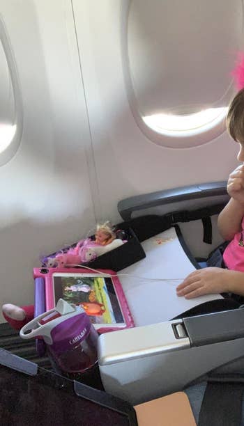 Reviewer's photo of a child watching the tablet on the tray in the plane