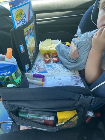 reviewer's photo of their child coloring on the travel tray