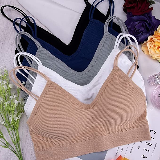 five bralettes laid out and surrounded by flowers