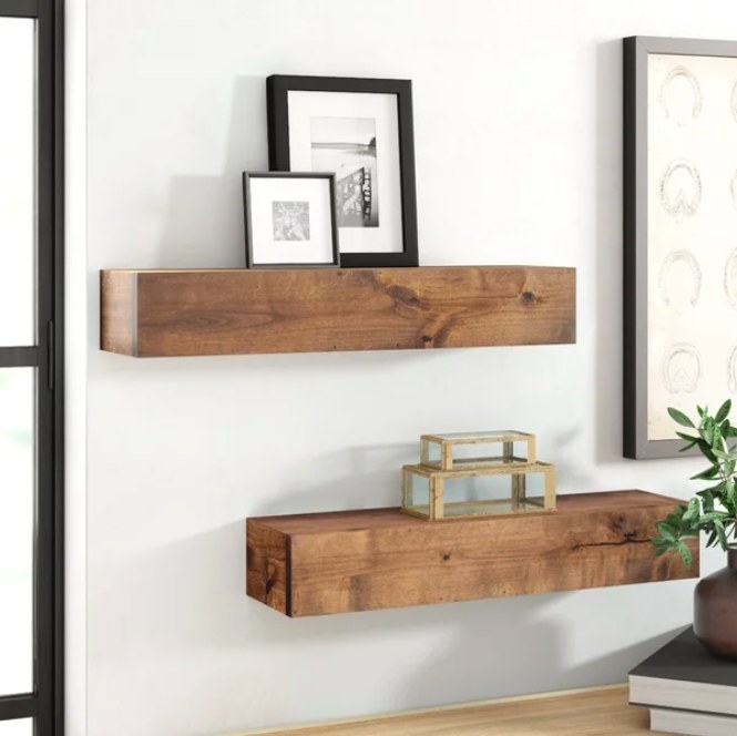 Two floating wood shelves with accessories on them