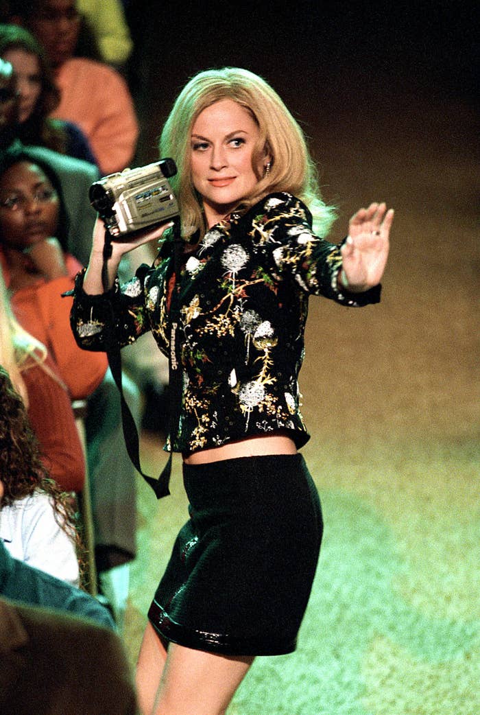 Amy holding a camera and mimicking the girls dancing on stage