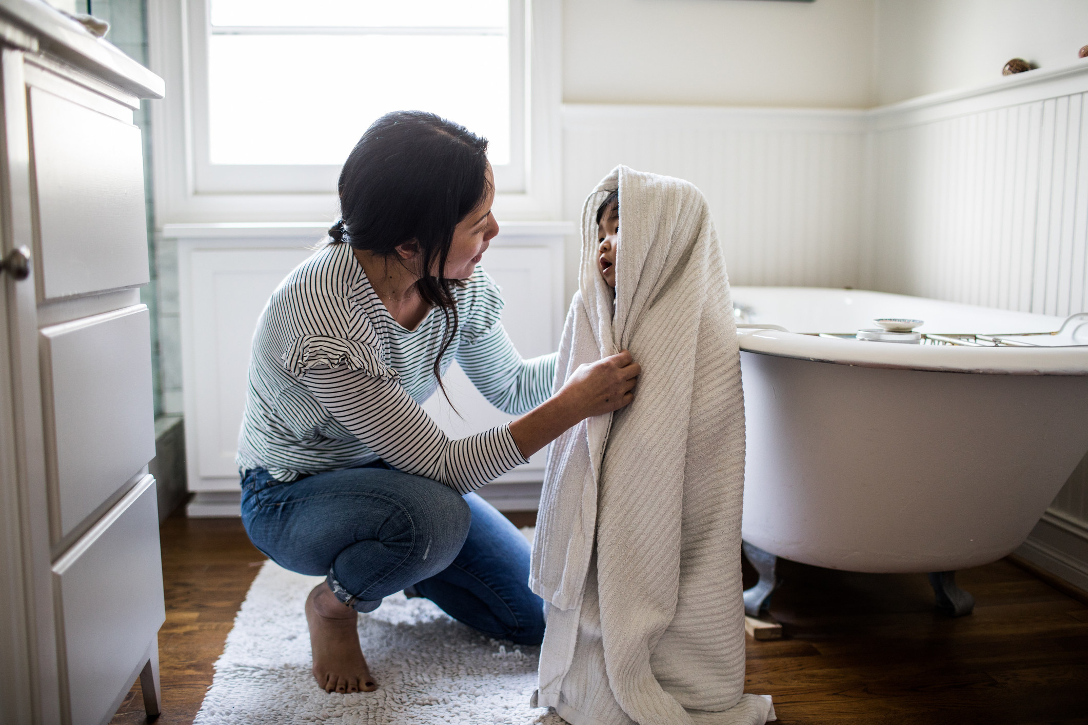 A woman drying a small child out of the bath
