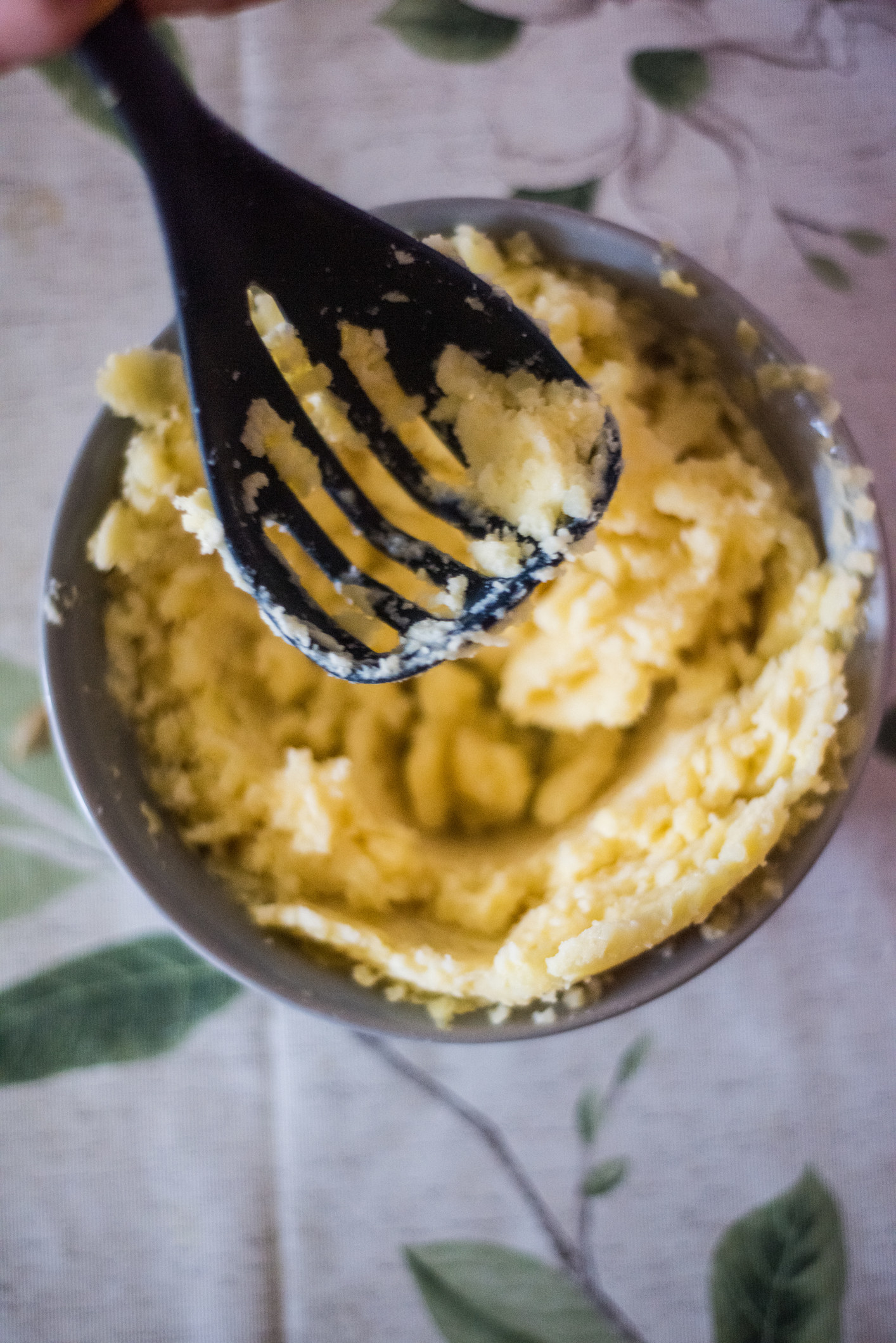 Mashing boiled potatoes in a bowl